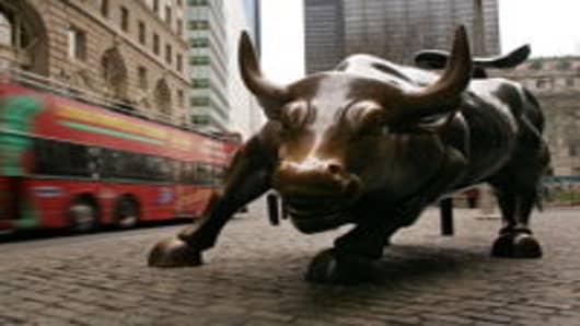 A tour bus passes the Wall Street bull in the financial district January 22, 2007 in New York City.