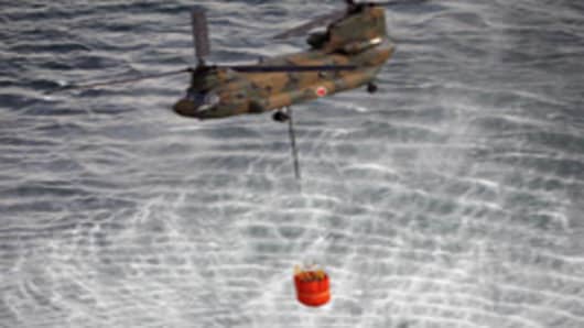 Japanese Self Defence Force's CH-47 Chinook helicopter holding more than seven tons water each with large buckets from the sea