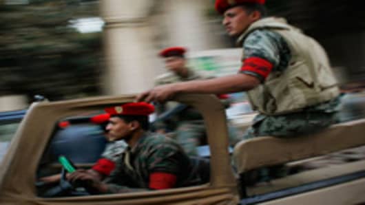 Egyptian security forces race through the streets near the scene Interior Ministry building that caught fire March 22, 2011 in downtown Cairo, Egypt.