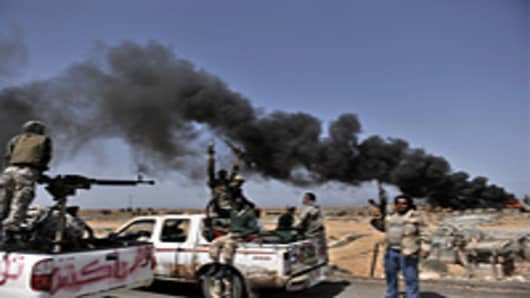 Libyan rebels progress westward from the town of Bin Jawad towards Muammar Gaddafi's home town of Sirte on March 28, 2011 as NATO finally agreed to take over full command of military operations to enforce a no-fly zone in Libya from a US-led coalition.