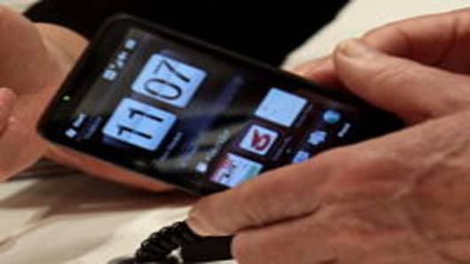 A visitor examines an HTC smartphone at the Vodafone stand at the CeBIT Technology Fair in Hannover, Germany.