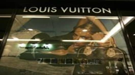 A shopper walks past a Louis Vuitton store at a shopping center on June 17, 2005 in Beijing, China. World famous brand sales in the Chinese market are forecast to grow by about 8 percent each year, according to state media.