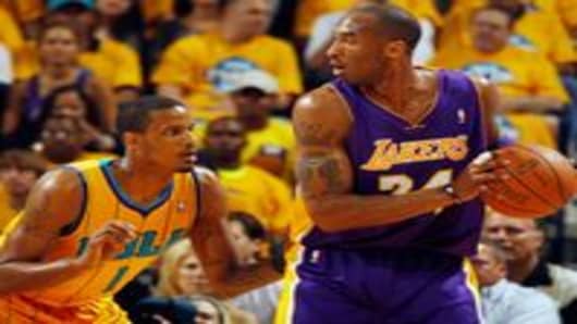 Kobe Bryant looks to pass the ball around Trevor Ariza in Game 3 of the Western Conference Quarterfinals
