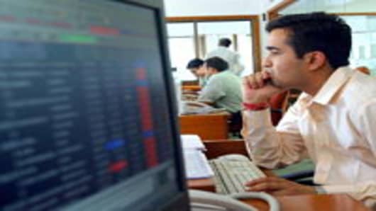 An Indian stock broker watches his computer screen at brokerage company at the Mumbai Stock Exchange.