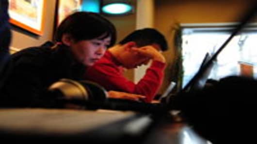 A woman surfs the internet on a laptop computer at a wireless cafe in Beijing, China.