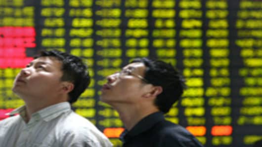 Investors watch a display at a stock exchange in Huaian, Jiangsu Province, China.