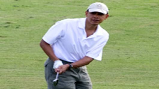S President Barack Obama watches his shot as he plays golf on the 9th hole at the Mid Pacific Country Club in Kailua, Hawaii, December 28, 2010.