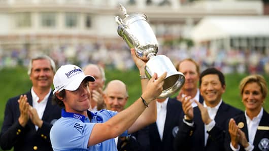 ory McIlroy of Northern Ireland holds up the trophy after winning the 111th US Open by eight strokes over Jason Day with a record 268 at Congressional Country Club on June 19, 2011, in Bethesda, Maryland.