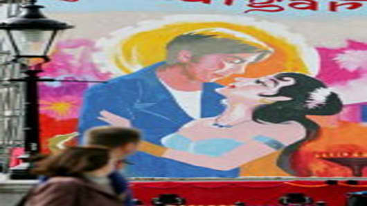 Commuters pass a giant painting of a Bollywood film poster in Trafalgar Square before heading to work on August 17, 2007 in London, England. The painting will be finished over a period of days during the Indian Festival in Trafalgar Square.