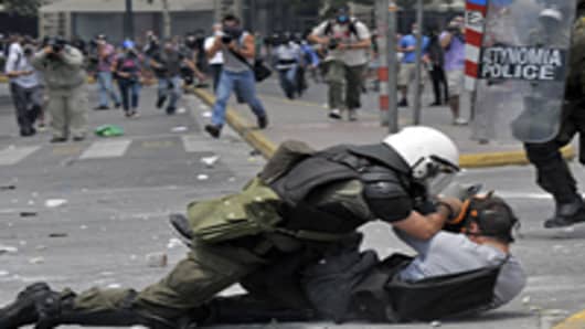 A riotpoliceman arrest a protestor during clashes in front of the Greek Parliament.