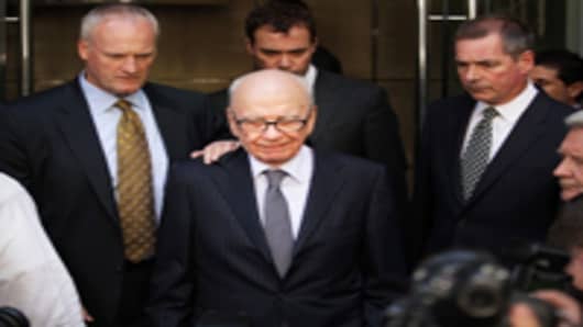 News Corp. Chairman Rupert Murdoch looks down as he leaves the One Aldwych Hotel surrounded by his personal security team to speak with reporters after meeting with the family of murdered school girl Milly Dowler on July 15, 2011 in London, England.