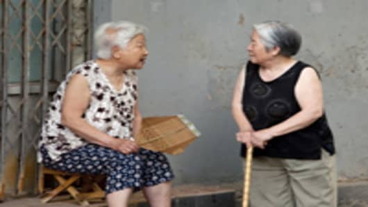 Two old women chat outside their homes in Hutong XiSi, one of the old neighborhoods in Beijing, China.