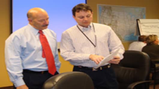Ken Melchiorre, right, CH2M Hill's vice president for government facilities and infrastructure, leads a disaster response training session at the company's office in Washington, D.C.