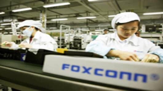 Employees work on the assembly line at Hon Hai Group's Foxconn plant in Shenzhen, Guangdong province, China.