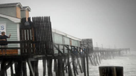 Denis Hromin stands on a pier to get a picture of the beach during Hurricane Irene August 27, 2011 in Kill Devil Hills, North Carolina. Hurricane Irene hit Dare County, which sits along the Outer Banks and includes the vacation towns of Nags Head, Kitty Hawk and Kill Devil Hills.