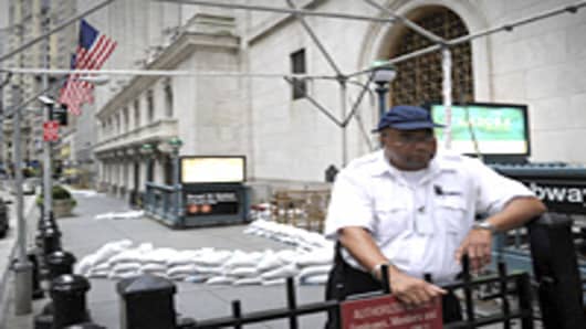 A security guard near the sand bagged front entrance of the New York Stock Exchange August 27, 2011. New York City ordered more than 300,000 people who live in flood-prone areas to evacuate as Hurricane Irene is forecast to reach the city.