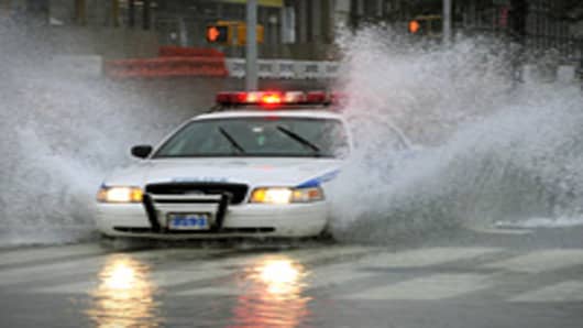 A New York City Police car drives through a flooded intersection on 43nd Street in New York on August 28, 2011 as Hurricane Irene hits the city and Tri State area with rain and high winds.