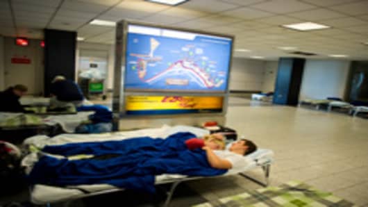 A young couple from Germany rest on a cot at LaGuardia Airport August 29, 2011 in New York.