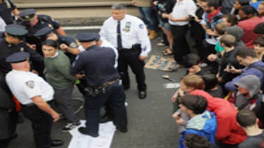 Police arrest demonstrators affiliated with the Occupy Wall Street movement after they attempted to cross the Brooklyn Bridge on the motorway on October 1, 2011 in New York City.