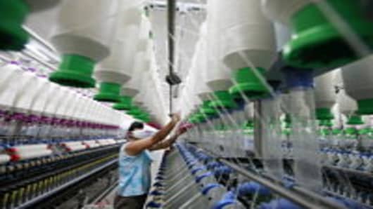 A worker operates machines for making yarn at a textile factory in Huaibei, east China's Anhui province.