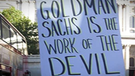 A protester in London targets U.S. investment bank Goldman Sachs with a sign comparing the firm to "the work of the Devil."
