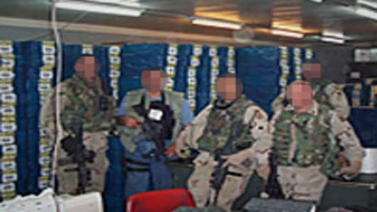 US military officers in front of billions of dollars in cash inside the vault of the Central Bank of Iraq.