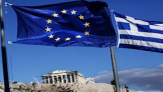 The European Union and Greek national flags fly near the Parthenon temple on Acropolis hill in Athens, Greece.