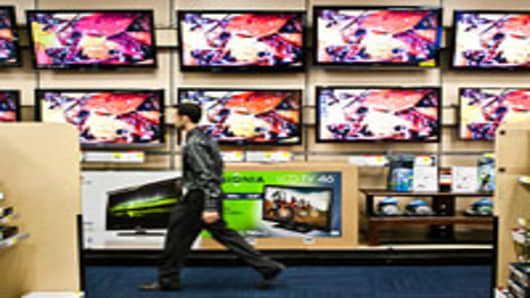 A salesman passes In front televisions displayed for sale at a Best Buy store in New York.