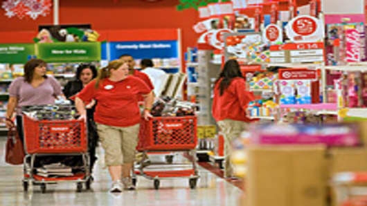 Target Corp. employees restock merchandise while customers shop at a Super Target store in Denver, Colorado.