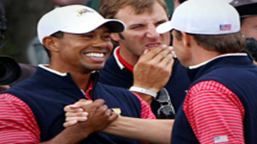 Tiger Woods of the U.S. Team shakes hands with Nick Watney of the U.S. Team after winning his match on the 15th hole during the Day Four Singles Matches of the 2011 Presidents Cup
