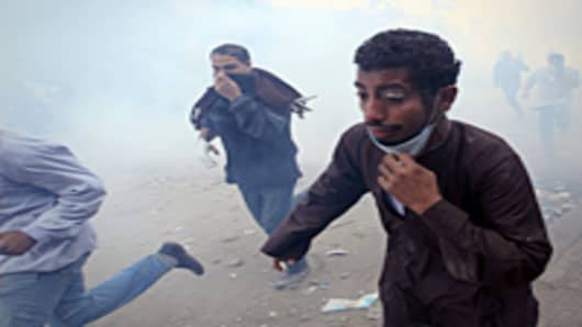     Egyptian protesters run for cover on the third day of clashes with security forces at Tahrir Square in Cairo on November 21, 2011.