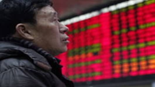 An investor watches the electronic board at the stock exchange in Shanghai, China.