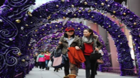 Pedestrians walk through a Christmas decoration at West Nanjing Road in Shanghai, China.