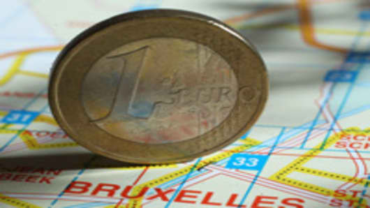 A one Euro coin stands on a map of Brussels.