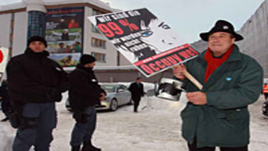 Occupy protesters make noise clanking pots in front of the main gate to Davos congress center on January 25, 2012 in Davos, Switzerland
