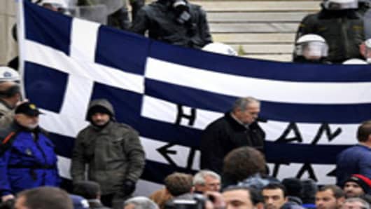 Protesters hold a Greek flag at the steps of the parliament during a 24-hours general strike in Athens.