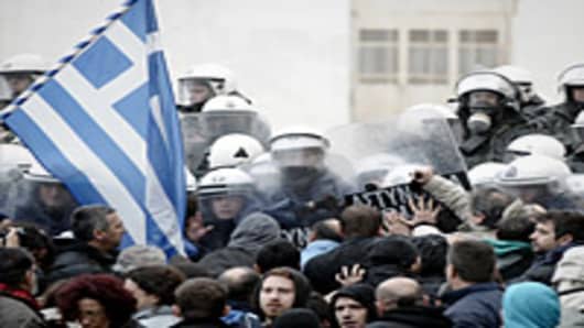 Protesters clash with riot police while they try to enter the parliament during a 24-hours general strike in Athens.