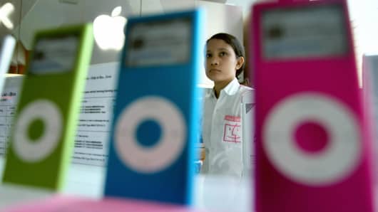 An attendant waits for customers, displaying apple iPods at a shopping mall in Jakarta, Indonesia.