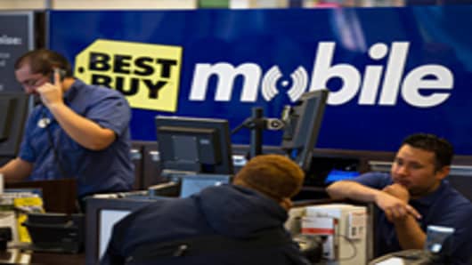 Employees help customers at a Best Buy store.