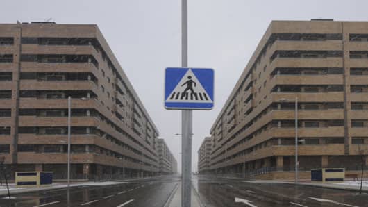 A road sign stands between blocks of empty apartments at Francisco Hernando village at the Sesena real estate development near Madrid.Out of 13,000 apartments that were meant to make up the development of Sesena only 5,100 were built, many of which are now uninhabited with those Spaniards who bought them as investments trying to sell them off for huge losses.One is example is Juan Carlos Caballero who bought an apartment in Sesena in 2008 for 185,000 euros alongside his father who had previously
