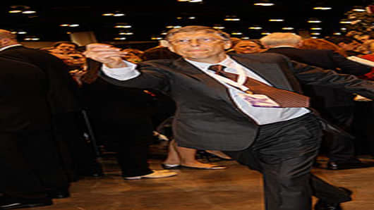 Bill Gates, Microsoft's Chairman and a Berkshire director, gives the newspaper toss challenge a try.
