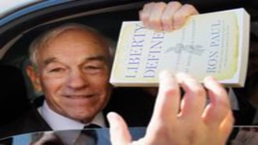 Rep. Ron Paul gives a copy of his book back to a supporter after he signed it.