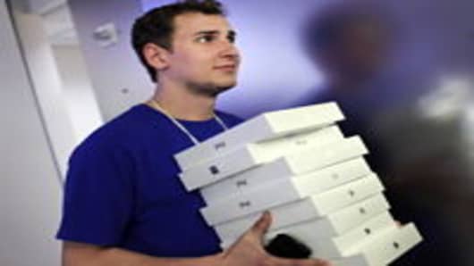 An Apple employee carries boxes of new iPads