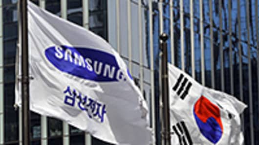 Samsung Electronics flag and South Korean flag (R) flutter outside its headquarters in Seoul.
