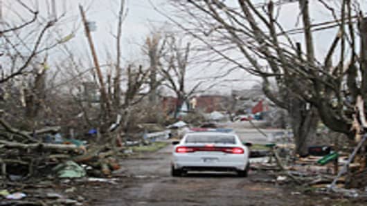 A police car drives down a tornado-ravaged street March 3, 2012 in Henryville, Indiana. Dozens of people were killed as severe weather and tornados ripped through the South and Midwest on March 02, 2012.