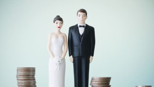 Wedding figurines are placed on top of coins.