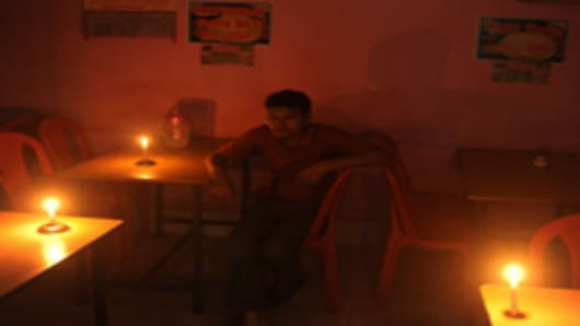 An Indian diner waits for his meal in candle light at a hotel during a power cut in Siliguri on July 31, 2012. A massive power failure hit India for the second day running as three regional power grids collapsed, blacking out more than half the country in a crisis affecting over 600 million people.