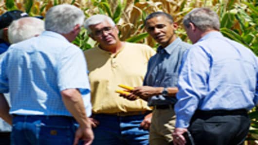 US President Barack Obama (2nd R) inpects drought stricken corn with US Secretary of Agriculture Tom Vilsack (R) and farmer Don McIntosh (C) and his brothers on the McIntosh farm in Missouri Valley, Iowa, on August 13, 2012.