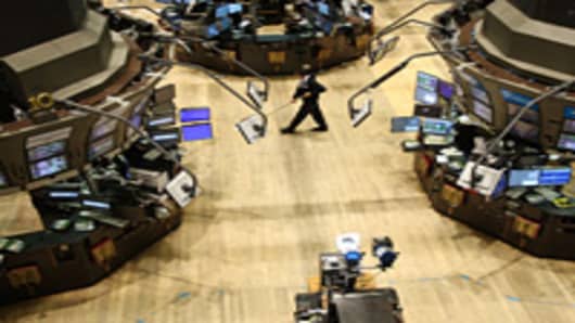 A janitor sweeps an empty trading floor at the New York Stock Exchange.