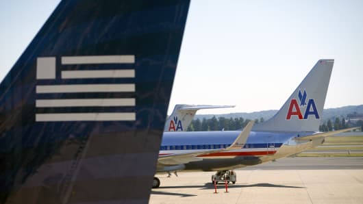 American Airlines and US Airways aircraft sit on the tarmac at Ronald Reagan National Airport in Arlington, Virginia.